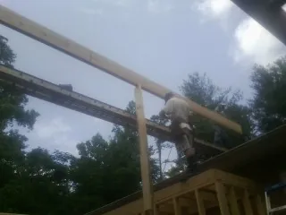 Carpenter setting a ridge beam over a new addition frame — Ice Dam Removal by Roofing Brothers in Manitowoc