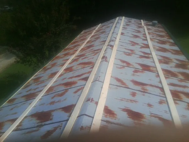 Rusted metal roof panels with new wood purlins before replacement — Storm Damage Roof Repair in Manitowoc by Roofing Brothers