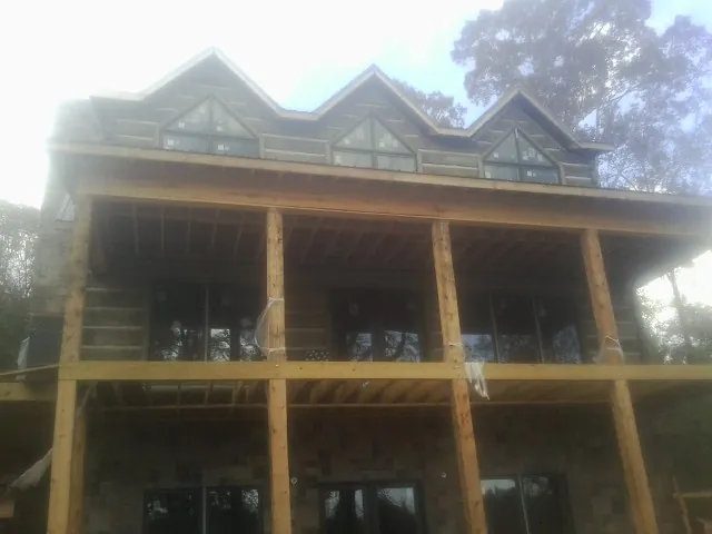 Dormers and porch framing on a large log home under construction — Roof Coating work by our crew in Manitowoc