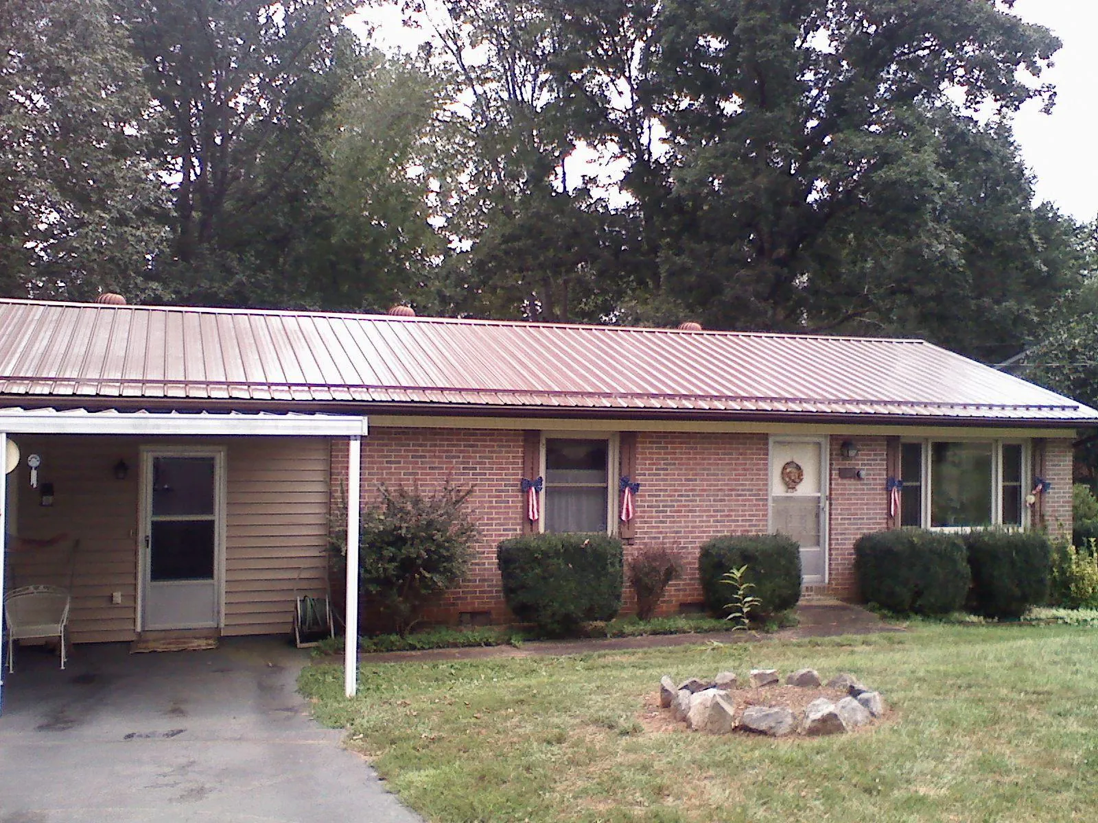 Bronze metal roof and carport on a brick ranch home — Roof Repair work by our crew in Manitowoc
