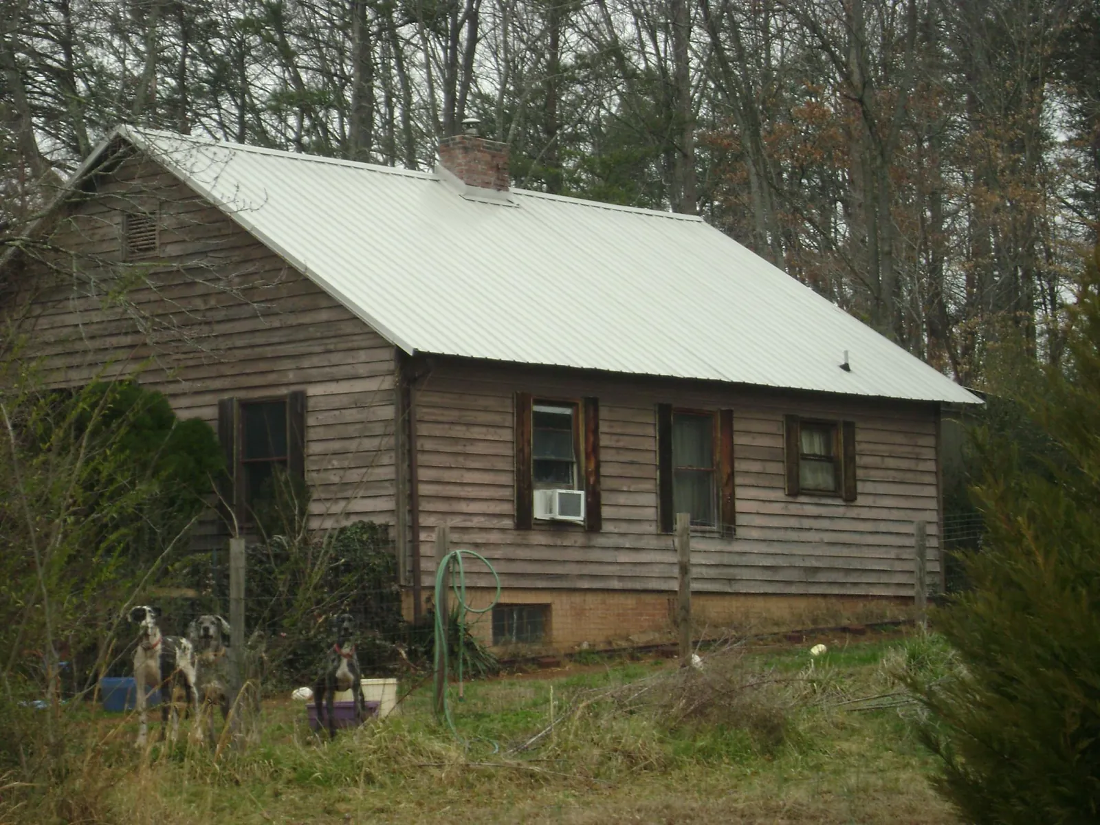 White metal roof on an old wood sided farmhouse, from a Metal Roof Installation job in Manitowoc